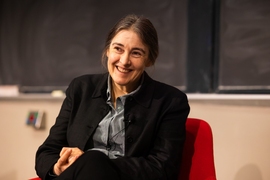 Clare Grey is seated before a blackboard