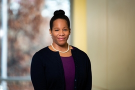 Portrait photo of Melissa Smith in front of a window and a yellow wall.