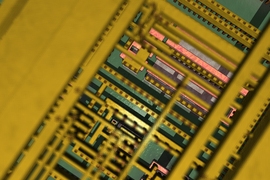 Very close-up photo of a computer chip, with mostly green and yellow components
