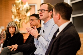 Side view of four people seated on a panel