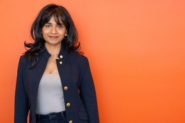Tishara Garg portrait photo against an orange wall