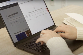 Hands typing on a laptop displaying the MIT Learn homepage