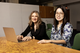 Regina Barzilay and Wenxian Shi sit together at a table, posing for a photo