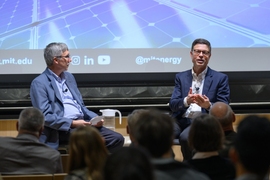 Kurt Kelty speaks on a stage with William Green looking on. Both are seated.