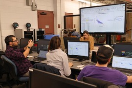 Three students and instructor learning at computers.