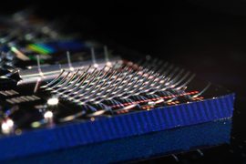 Photonic chip covered in microscopic structures that curl upward