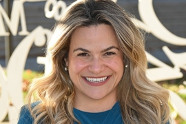 A woman in a light blue shirt smiles