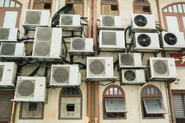 The outside of a building with numerous air conditioner compression units.