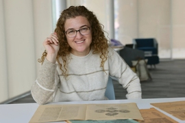 Lerna Ekmekcioglu, seated at a table with old documents on it