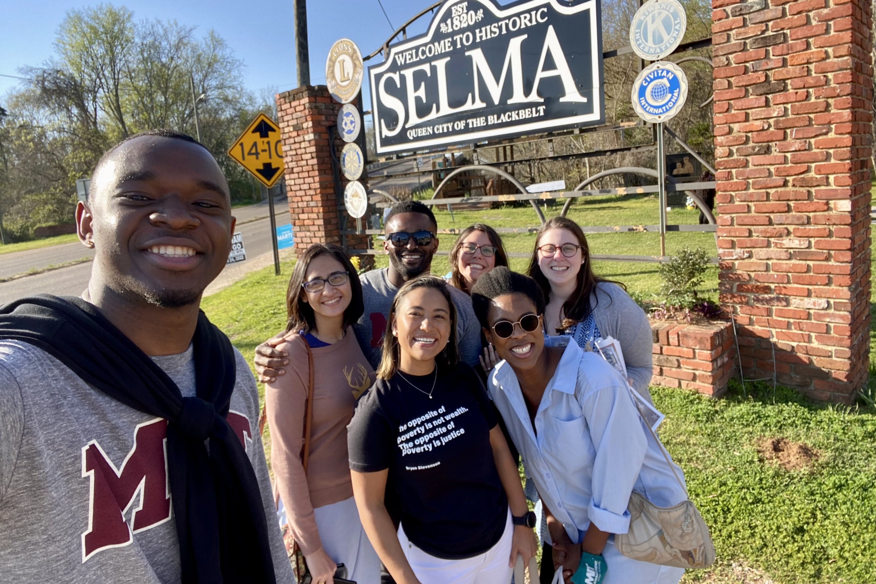 Left to right: Students Clyde-Blaise Niba, Naman Galhotra, Johana Muriel Grajales, Courtney Jacobovits, Patrick Akujobi, Vanessa Labrador, and Chavie Sharfman Sosa pose in front of the “Welcome to Historic Selma” sign, in Alabama. 