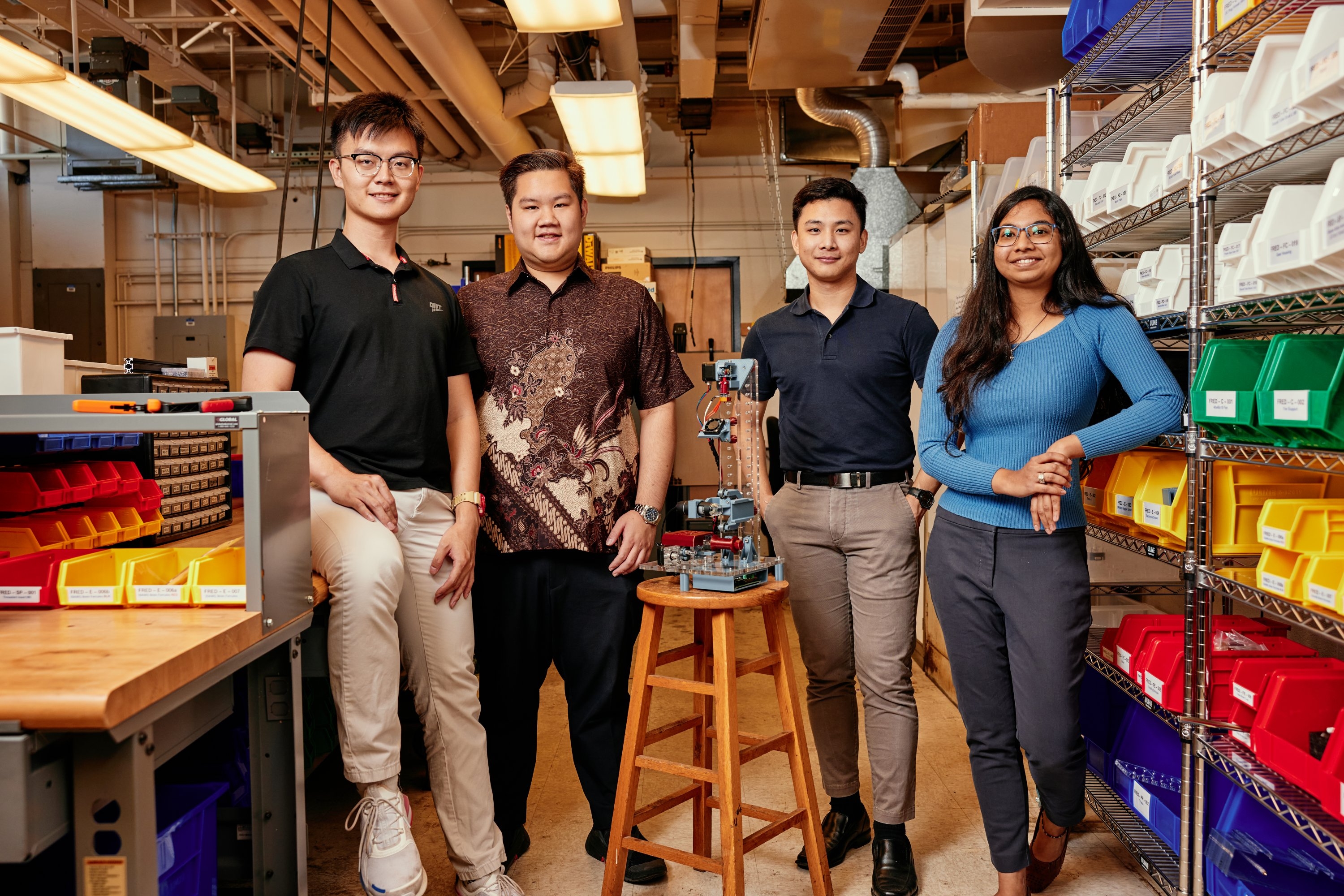 A team of MIT graduate students designed a low-cost desktop fiber extrusion device (FrED) and set up an assembly factory inside an MIT lab. Left to right: Rui Li MEng '22, Russel Bradley, Tanach Rojrungsasithorn MEng '22, and Aviva Jesse Levi MEng '22, pose with FrED.