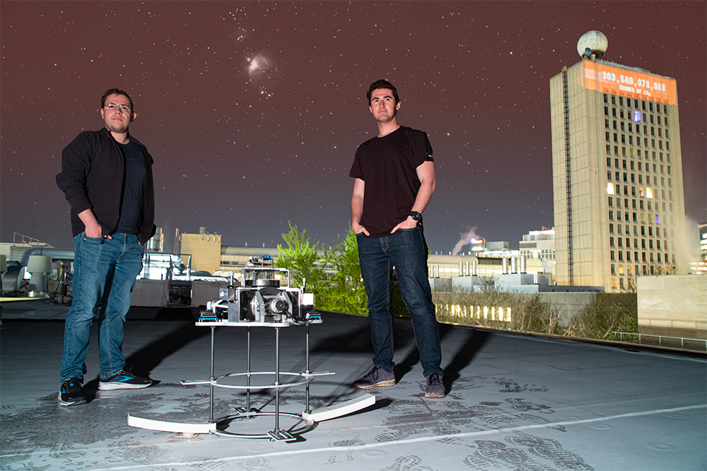 Evan Kramer (left) stands on the roof of MIT Building 33 with a camera and tripod to create an Astro Portrait of fellow MIT graduate student Noah Salk. Single image: A camera was set up on the roof of MIT Building 35 and a long focal length lens was used to capture a tight composition with the MIT Dome in the background in this multi-roof shot.
