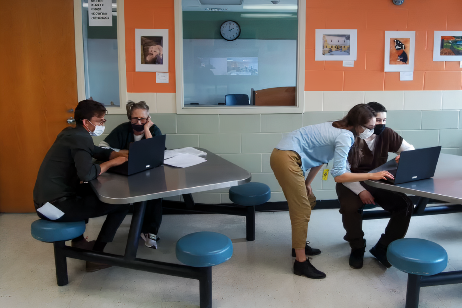 MIT graduate students Marisa Gaetz (second from right, standing) and Martin Nisser (left) assist students in a coding class at a local correctional facility.