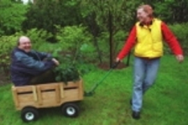 Lee Knight, a senior in mechanical engineering, pulls Professor David Wallace and a plant in the Green Wagon, which transports items and then converts to a bench on which to sit in the garden and work.