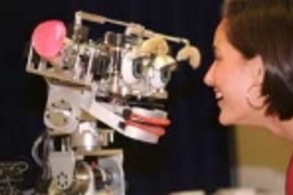Dr. Cynthia Breazeal plays with Kismet, the robot that mimics and responds to human emotions.