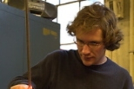 Instructor Chris Laughman, a research engineer in electrical engineering and computer science, cuts molten glass to make a handle.