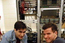 Graduate student Keith J. Winstein (left) and junior Joshua Mandel check the circuit board inside a computer that hosts the new campus-wide music library they designed.