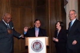 Cambridge City Council member and former mayor Kenneth Reeves (left) and Mayor Michael Sullivan (at podium) share a laugh with Rebecca Vest and President Charles M. Vest as they present the Vests with a key to the city at the MIT Community Service Awards ceremony. The Vests were recognized for their commitment to positive town-gown relations during their 14 years in the President's House.