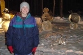 Freshman Anna Massie poses in front of sculptures in the Ice Art Park in Fairbanks.