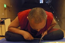 Lama Dhondup Tsering, a Buddhist monk, works painstakingly Monday to create a sand mandala at Simmons Hall. It will be on view through Saturday.