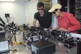 Assistant professor Nergis Mavalvala, right, and Ph.D. student Thomas Corbitt look over the laser system they use to cool a coin-sized mirror to within one degree of absolute zero.