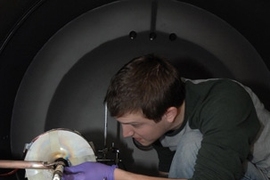 Department of Aeronautics and Astronautics graduate student Taylor Matlock works on adjusting a prototype of a new plasma rocket.