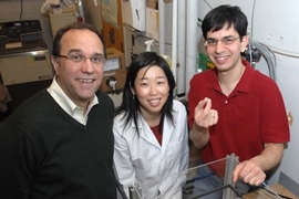 Recent PhD recipient Christophoros Vassiliou, right, holds the cancer monitoring device that he and Professor Michael Cima, left, and recent PhD recipient Grace Kim developed.