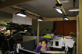 Visiting student Nan Zhao works in the test setup at the Media Lab under four LED fixtures controlled by the prototype adaptive system.