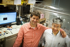 Postdoc Iftach Yacoby, left, and Shuguang Zhang, associate director of MIT’s Center for Biomedical Engineering, stand in front of their experimental setup. 