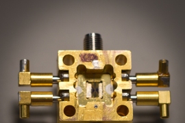 A superconducting circuit (small square, center) fits snugly into a housing that enables it to receive electrical signals inside a cooling tank.
