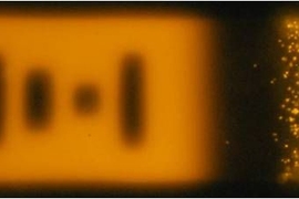 In this image, the microRNA fluoresces after binding to the particle. At left, a 'bar code' indicates which type of microRNA the particle is detecting.