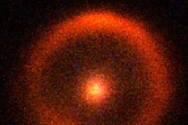 At the center of this infrared image is a massive red galaxy, 9.8 billion light-years from Earth, which acts like a cosmic magnifying glass, distorting the light from an even more distant galaxy, 17.3 billion light-years away. The result is a spectacular Einstein ring image of the background galaxy. The observations were made with the 10-meter Keck-11 Telescope on Mauna Kea, Hawaii.