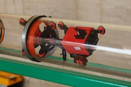 A test version of the new detection system is seen in the lab, where it underwent tests inside glass tubes to allow its operation to be observed. The propulsion module, at right, is fitted with electric wheels and motors to move the device through the pipe. The leak sensor, at left, is a drum-shaped membrane that can sense changes in pressure caused by the presence of a leak.