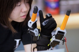Faye Wu, a graduate student in mechanical engineering, demonstrates the "supernumerary robotic fingers" device