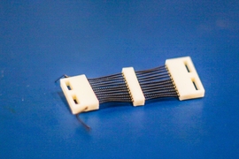 A close-up view of a 3-D-printed shape memory alloy (SMA) cartridge that packs 24 SMA actuators into a 1-inch-wide structure designed specifically for active compression garments.