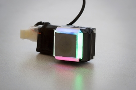 The GelSight sensor uses different-colored light, channeled down different faces of the cubic housing, to make three-dimensional measurements.