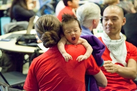 Baby Pau Wang-Levy with his mom Taylor Levy and dad Che-Wei Wang (background, red shirt), two organizers of the hackathon and students at the MIT Media Lab in the Playful Systems Group. 

