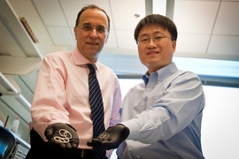 Professor Michael Cima (left) and alumnus Heejin Lee display early prototypes of the LiRIS devices. The pretzel-shaped silicone tubes can be inserted into the bladder, slowly releasing lidocaine over two weeks to treat various diseases, such as interstitial cystitis. 
