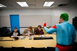Matthew S. Cain '02, in character as Captain Planet, leads an interactive challenge. Participants were asked to transform tabloid images into a message of hope for the planet.