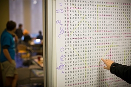 In hunt headquarters, a member of last year's winning team examines a large-scale version of a word search puzzle.