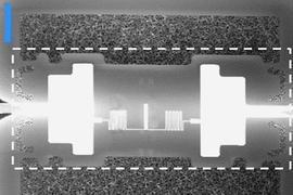 One of the researchers' devices during its transfer to an optical chip. Gold electrodes are deposited on a silicon nitride film at either end of a niobium nitride light detector.