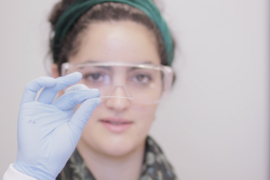 Christina Tringides, a senior at MIT and member of the research team, holds a sample of the multifunction fiber produced using the group’s new methodology.