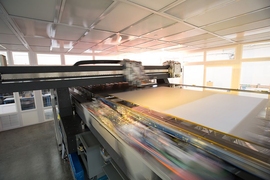 Kateeva's YIELDjet system (pictured here) is a massive version of an inkjet printer. Large glass or plastic substrate sheets are placed on a long, wide platform. A head with custom nozzles moves back and forth, across the substrate, coating it with OLED and other materials.