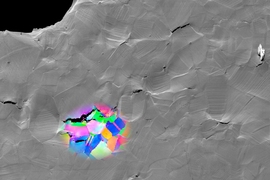 This scanning electron micrograph shows a sample of metal that fractured due to hydrogen embrittlement. The colored patches show data acquired by electron backscatter diffraction, revealing the grain structure surrounding selected cracks. Such images help show the correlation between microstructure and hydrogen embrittlement, and are used to identify the features that lead to hydrogen-assisted fra...