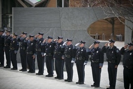 Officers salute moments before a convoy of four MIT Police cruisers pulled away from the Collier Memorial, symbolically opening it to the MIT community.