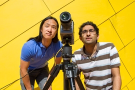 Graduate students Justin Chen and Neal Wadhwa set up a video camera to record the movement of MIT's Green Building.