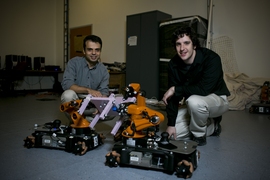 MIT postdoc Mehmet Dogar (left) and graduate student Andrew Spielberg pose robots to illustrate the collaborative assembly program they developed with Professor Daniela Rus.