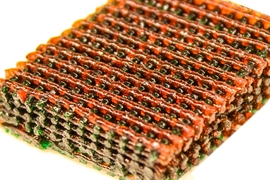 Photo shows the open lattice of 3-D printed material, with materials having different characteristics of strength and flexibility indicated by different colors.