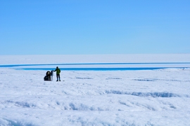 Ian Joughin and David Shean work on a GPS station nearby a supraglacial lake on the western margin of Greenland's ice sheet in 2013.