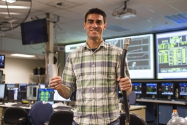 MIT PhD candidate Brandon Sorbom holds REBCO superconducting tapes (left), which are the enabling technology behind the ARC reactor. When it is cooled to liquid nitrogen temperature, the superconducting tape can carry as much current as the large copper conductor on the right, enabling the construction of extremely high&#8209;field magnets, which consume minimal amounts of power.